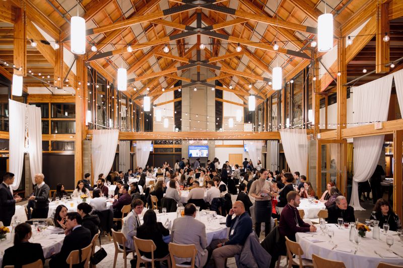 A full conference dinner underway inside Summit Lodge's timber-framed hall