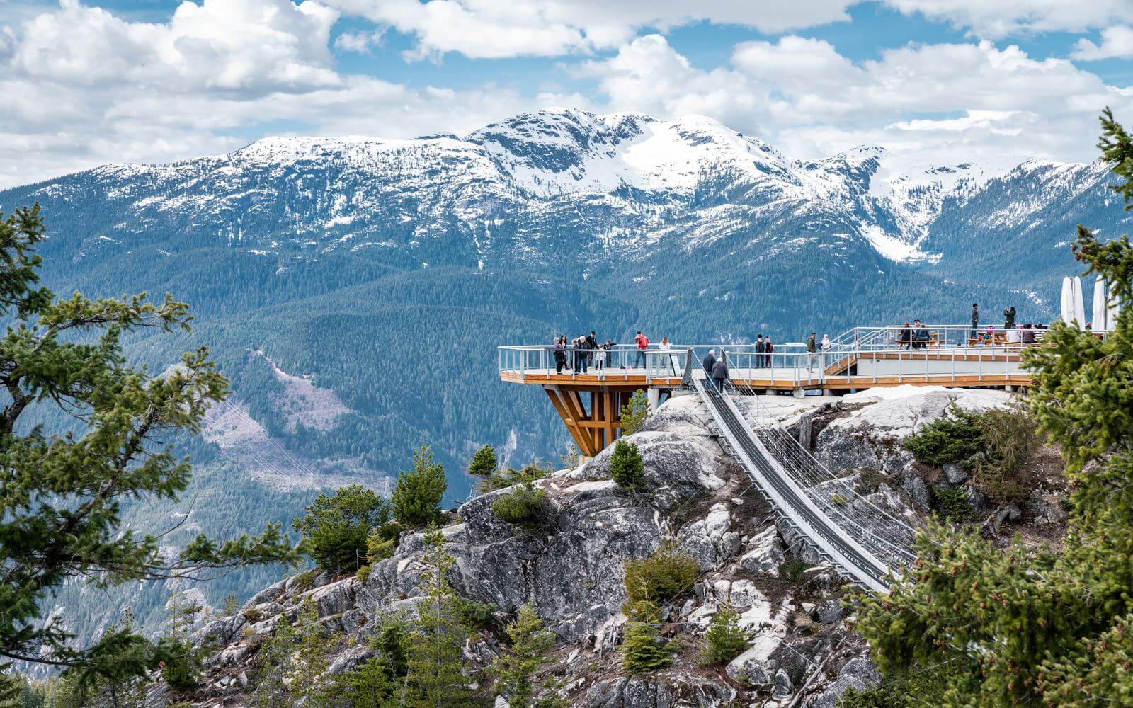 Sea to Sky Gondola summit viewing platform and suspension bridge with snow-capped coastal mountains beyond